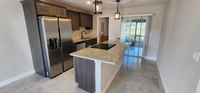 a kitchen with refrigerator and chairs