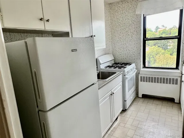 a kitchen with stainless steel appliances a refrigerator sink and white cabinets