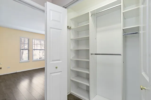 a view of walk in closet with empty racks