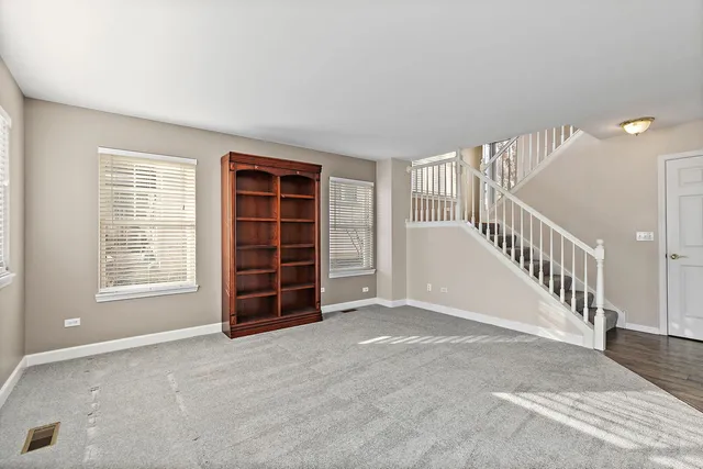 a view of an empty room with a window and stairs