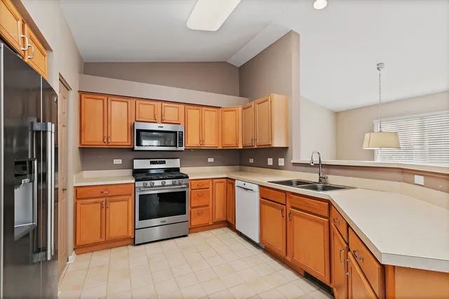a kitchen with stainless steel appliances granite countertop a stove sink and cabinets
