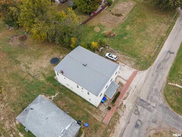 an aerial view of a house with swimming pool and large trees