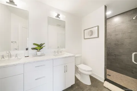 a bathroom with a granite countertop sink a toilet and a mirror