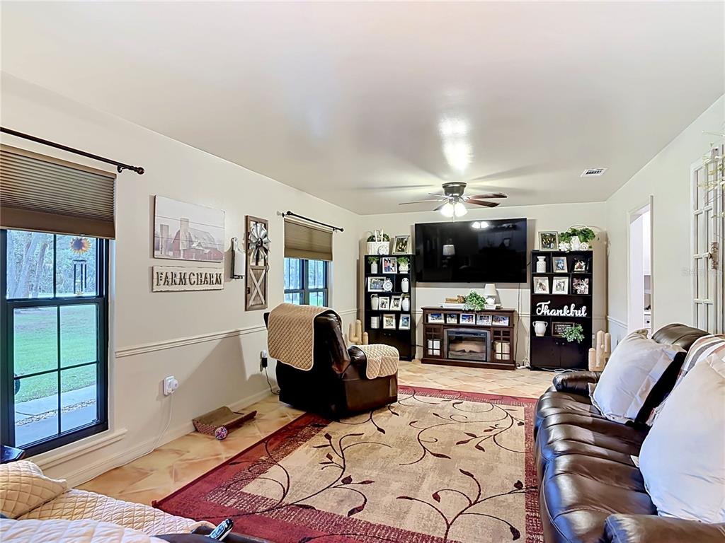 1395 Maytown Road Osteen, FL 32764 - Photo 11 of 65 a living room with furniture a flat screen tv and kitchen view
