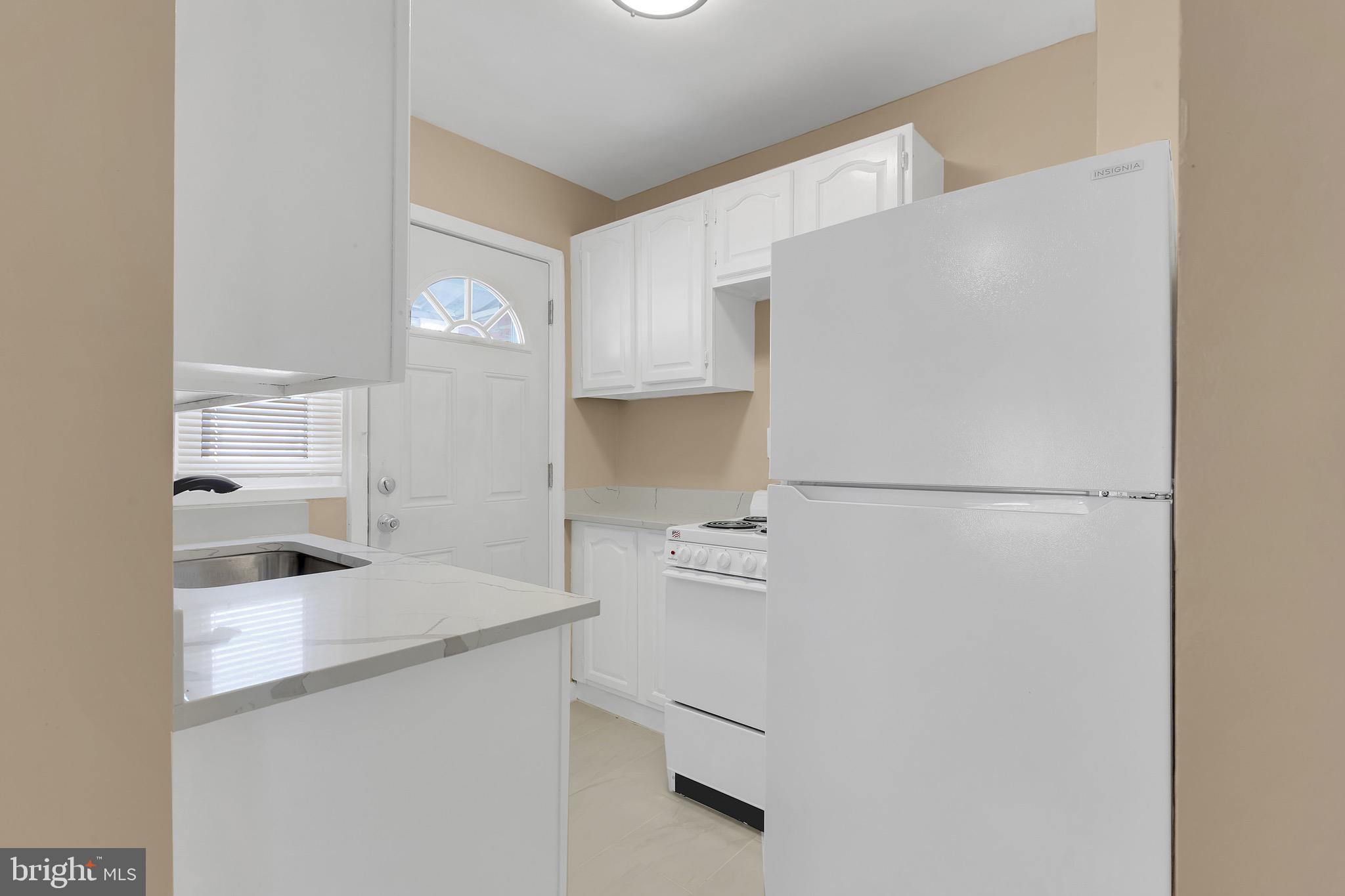 151 Darrington Street Southwest Washington, DC 20032 - Photo 14 of 22 a kitchen with white cabinets and refrigerator