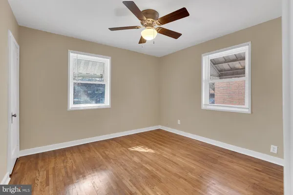 a view of an empty room with window and wooden floor
