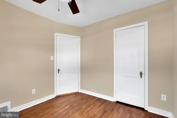 an empty room with closet and windows