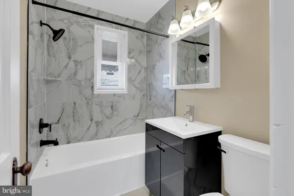 a bathroom with a sink vanity tub and shower