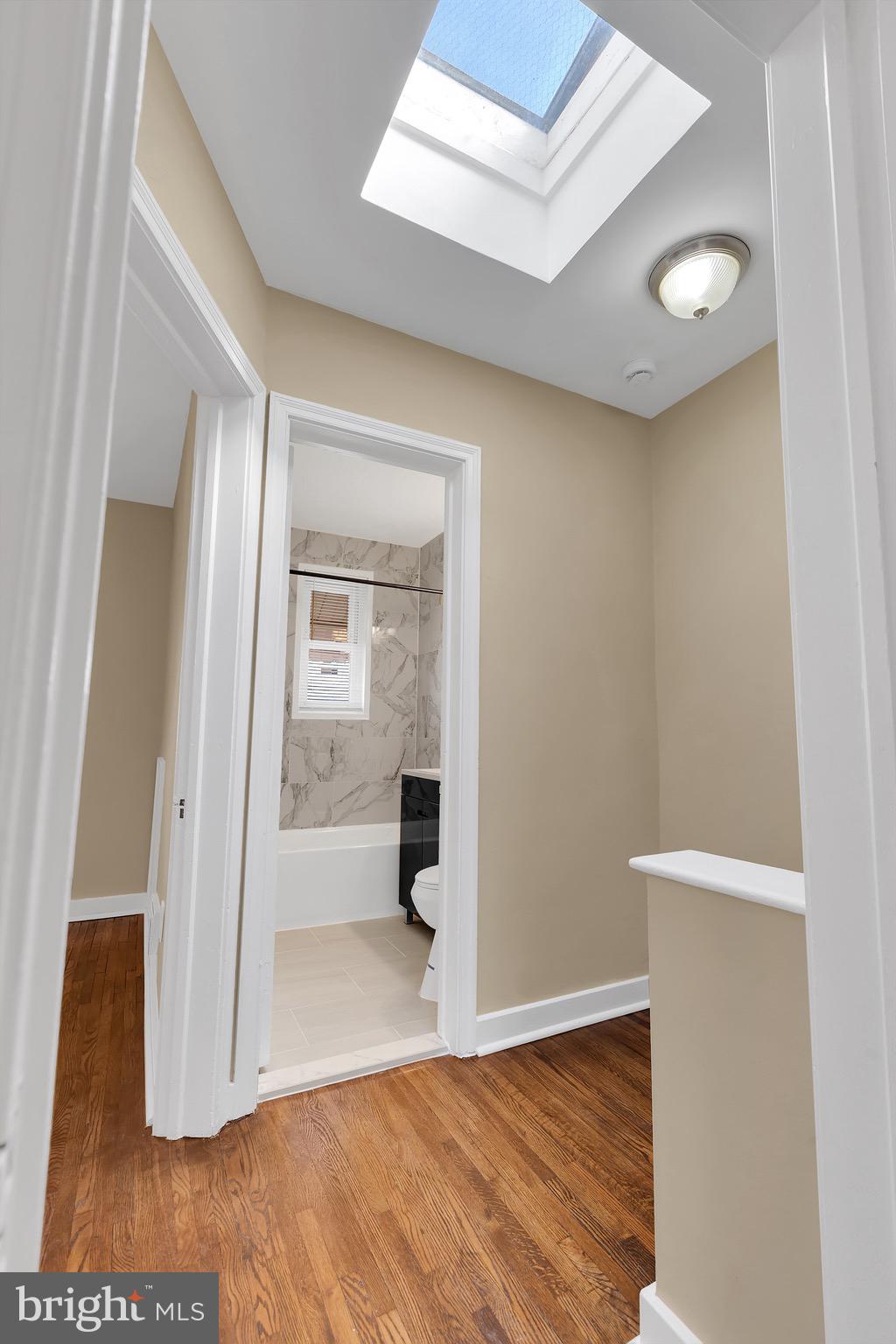 151 Darrington Street Southwest Washington, DC 20032 - Photo 10 of 22 an empty room with wooden floor and a bathroom