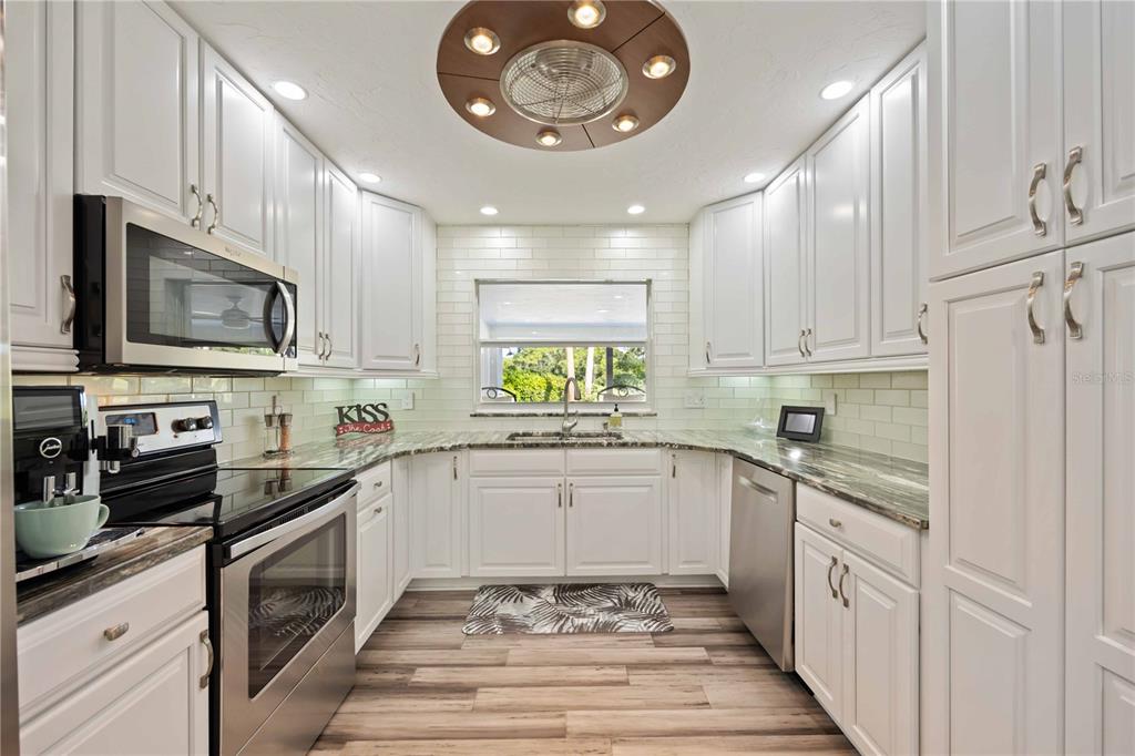 5025 Marsh Field Road Sarasota, FL 34235 - Photo 15 of 69 a kitchen with white cabinets and appliances