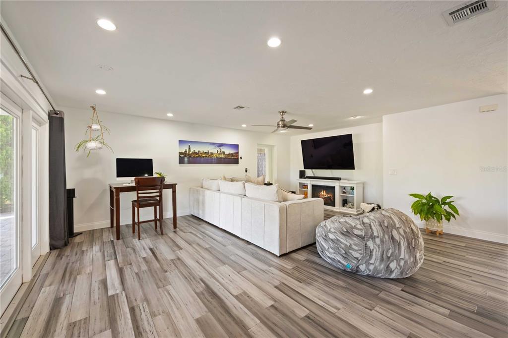 5025 Marsh Field Road Sarasota, FL 34235 - Photo 7 of 69 a living room with furniture a flat screen tv and a wooden floor