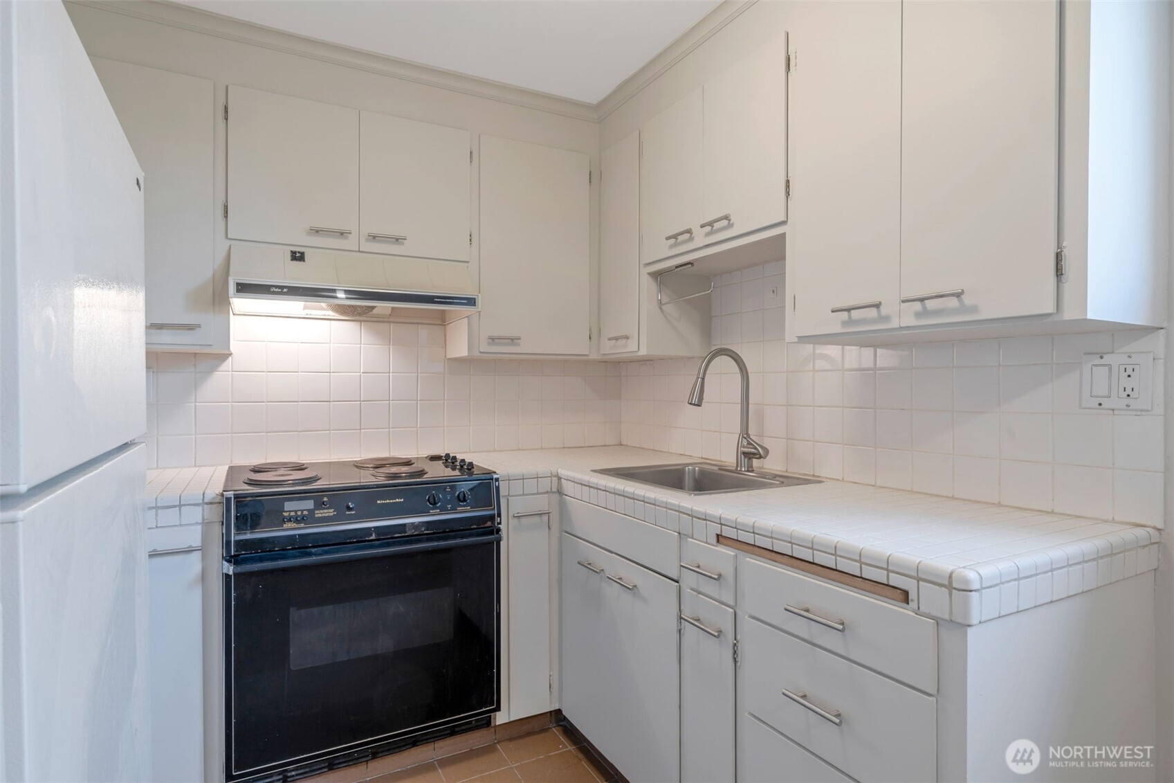 4324 Phinney Avenue North, Unit 1 Seattle, WA 98103 - Photo 14 of 20 a kitchen with granite countertop a sink stove and cabinets