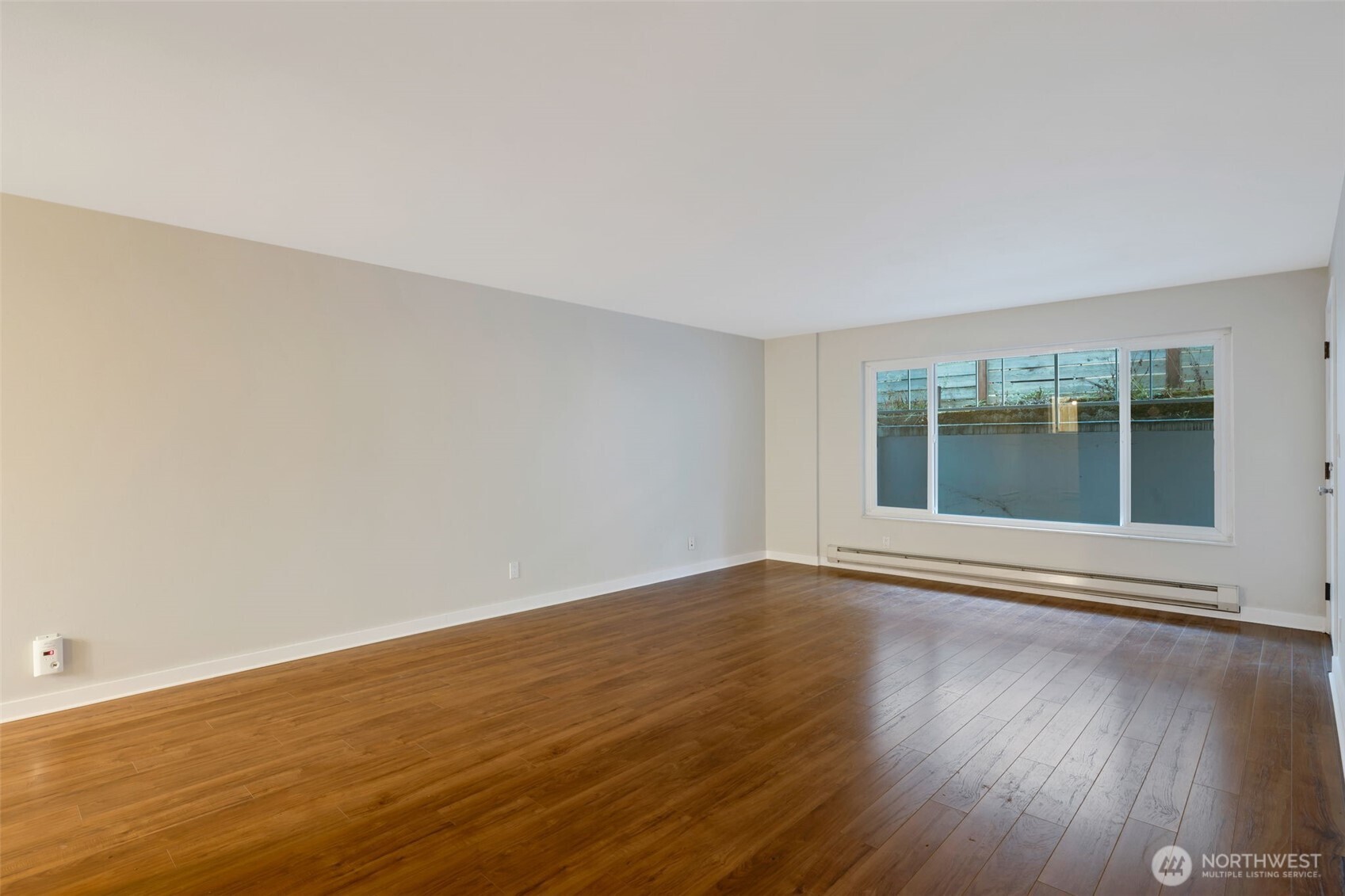 4324 Phinney Avenue North, Unit 1 Seattle, WA 98103 - Photo 7 of 20 a view of an empty room with wooden floor and a window
