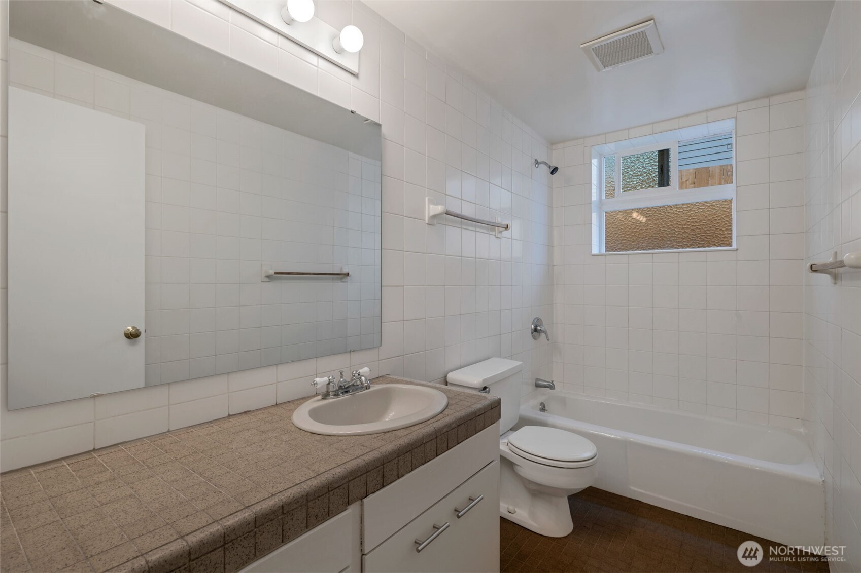 4324 Phinney Avenue North, Unit 1 Seattle, WA 98103 - Photo 9 of 20 a bathroom with a granite countertop sink toilet a mirror and shower