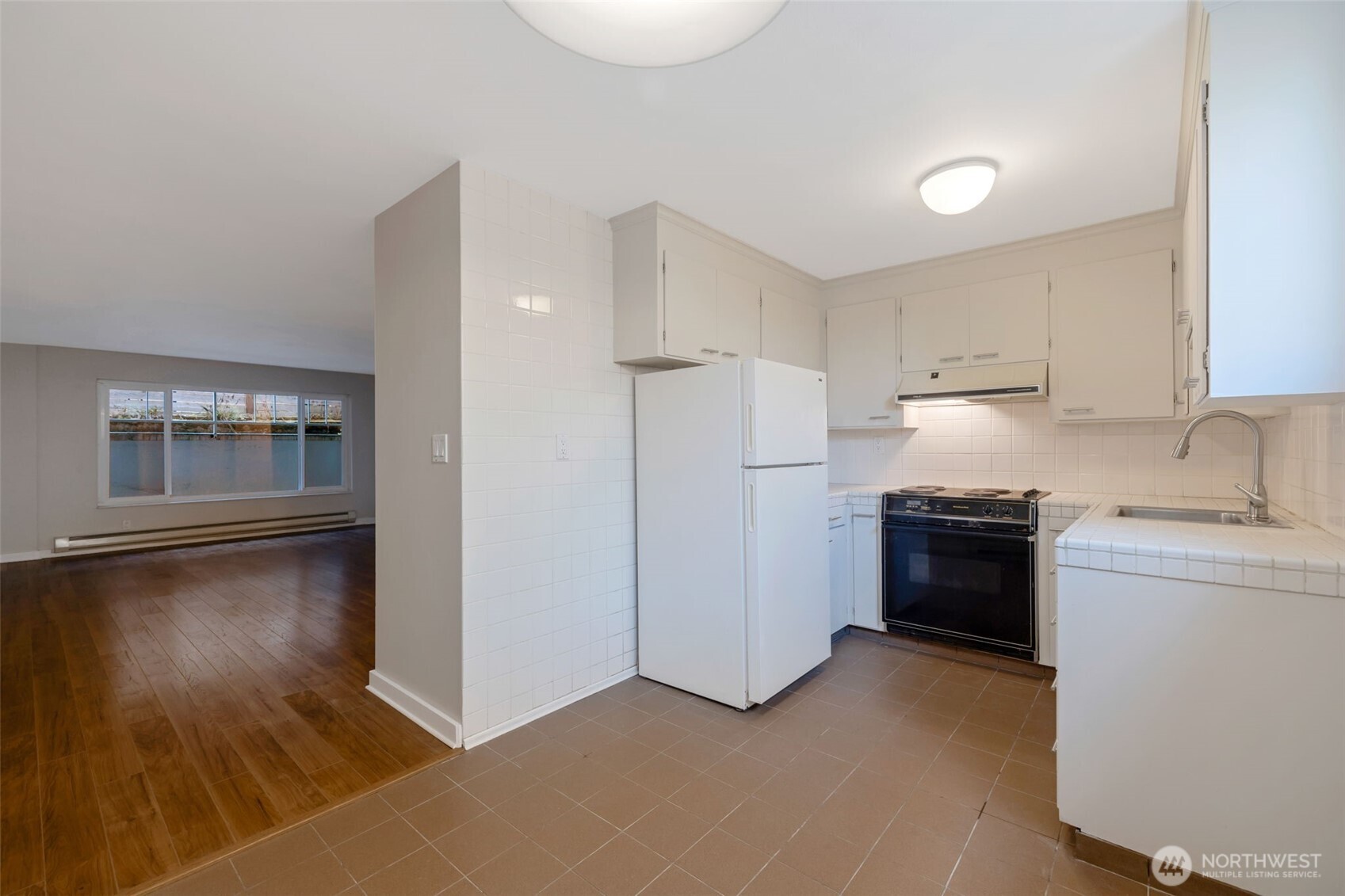 4324 Phinney Avenue North, Unit 1 Seattle, WA 98103 - Photo 10 of 20 a kitchen with stainless steel appliances granite countertop a refrigerator and a stove top oven