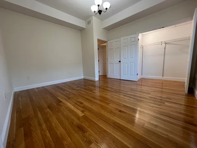 a view of an empty room with a chandelier fan