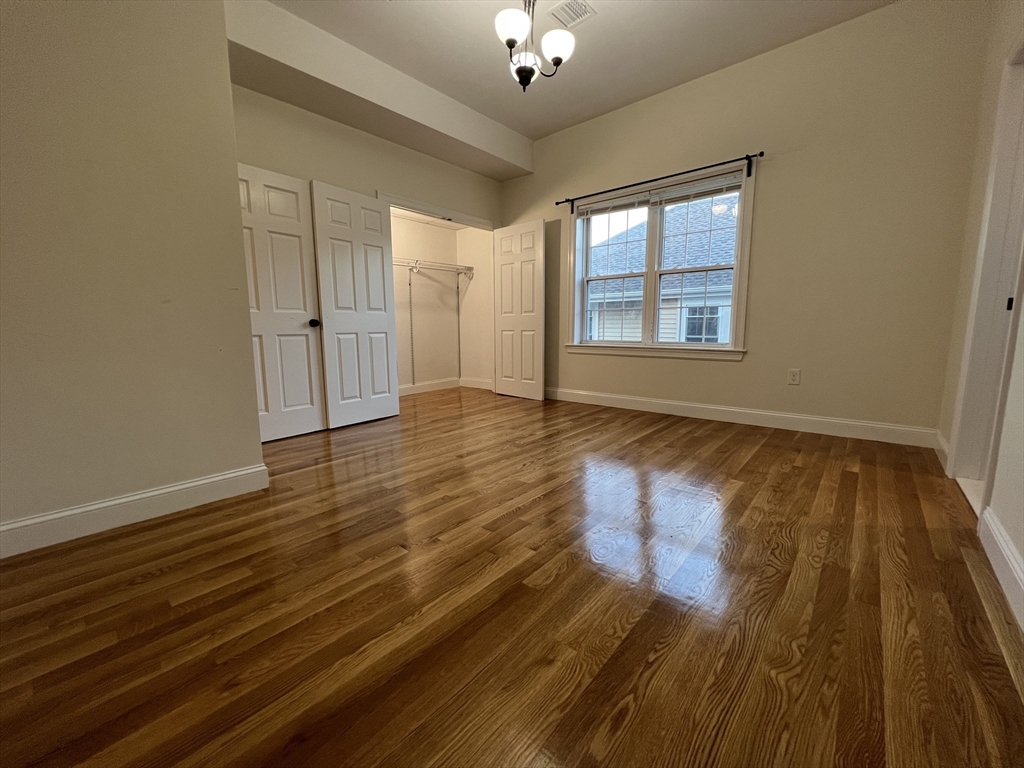 69 Appleton Street, Unit 22 Quincy, MA 02171 - Photo 5 of 8 a view of an empty room with wooden floor and a window