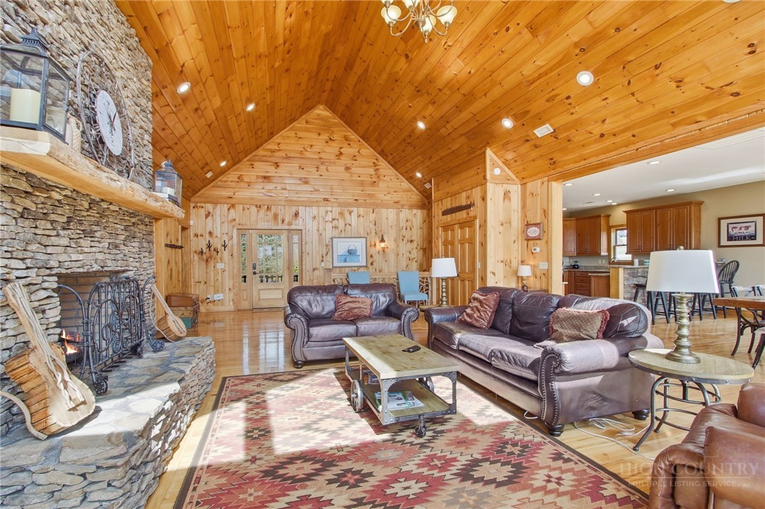 2081 Blackberry Road Boone, NC 28607 - Photo 15 of 45 a living room with furniture a fireplace and a dining table with wooden floor