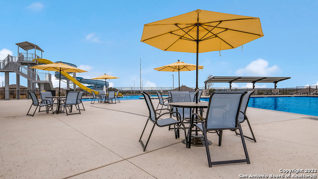 14671 Clay Rdg Run San Antonio, TX 78253 - Photo 32 of 42 a view of a patio with a table and chairs under an umbrella