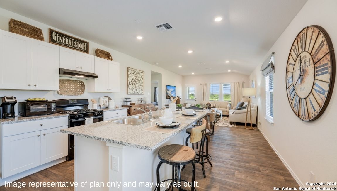 14671 Clay Rdg Run San Antonio, TX 78253 - Photo 5 of 42 a open dining room with stainless steel appliances kitchen island granite countertop a dining table chairs and a refrigerator