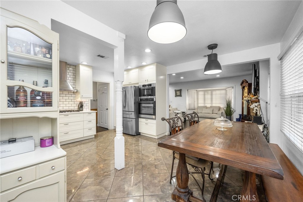1231 South Baker Street Santa Ana, CA 92707 - Photo 11 of 48 a kitchen with a table chairs stainless steel appliances and cabinets