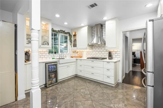 a room with kitchen island a sink and a stove top oven