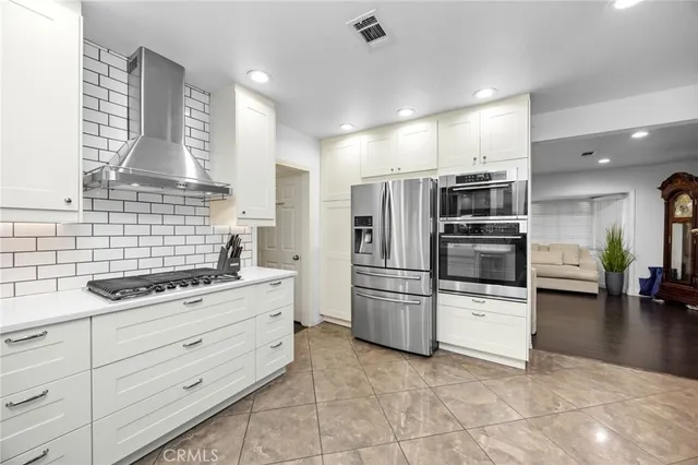 a kitchen with granite countertop a refrigerator and a stove
