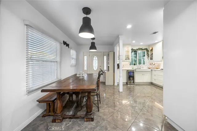 a dining room filled chandelier and kitchen view