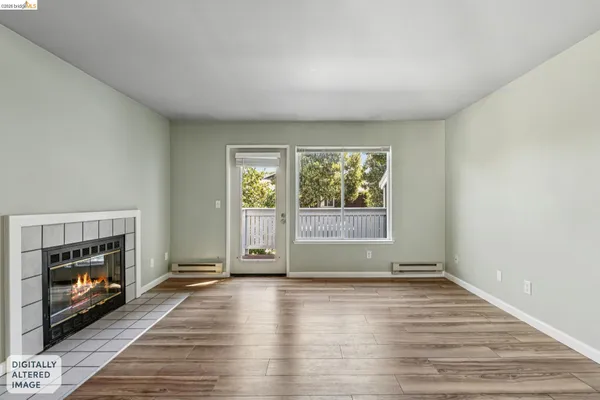 a view of an empty room with a fireplace and a window