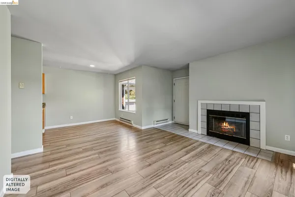 a view of an empty room with window and fire place