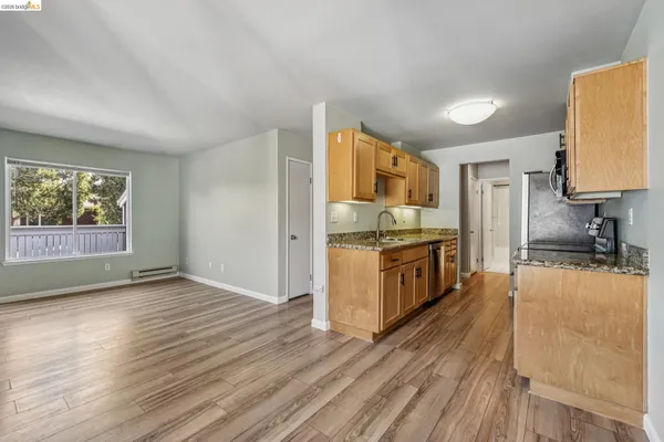 a kitchen with stainless steel appliances a stove top oven a sink a counter space and cabinets