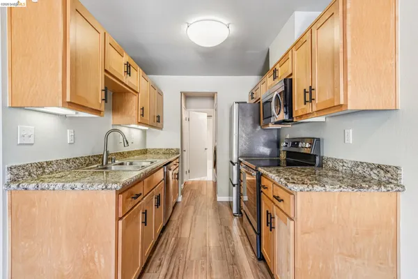 a kitchen with stainless steel appliances granite countertop a sink stove and cabinets