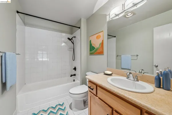 a bathroom with a bath tub sink mirror vanity and toilet