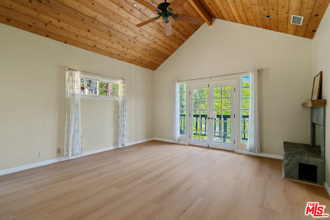 20912 Fontaine Road Topanga, CA 90290 - Photo 19 of 52 a view of a livingroom with a fireplace a ceiling fan and wooden floor