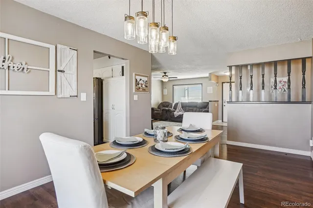 a view of a dining room with furniture a chandelier and wooden floor