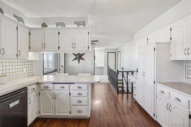 a kitchen with cabinets wooden floor and a sink