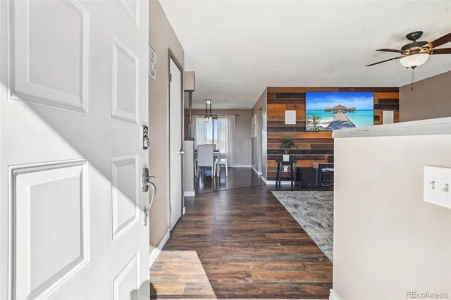 a view of a hallway with furniture and a kitchen view