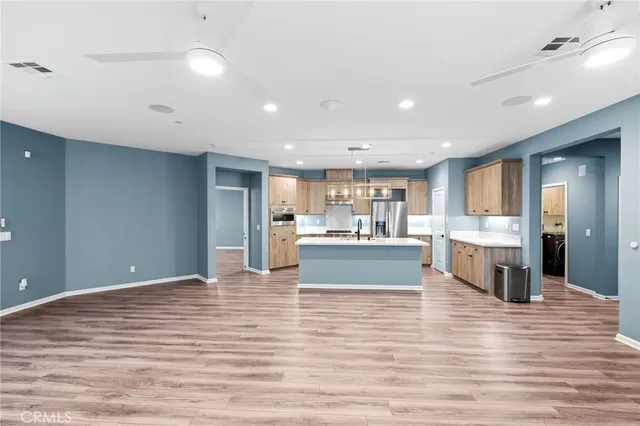 a large kitchen with kitchen island a sink stainless steel appliances and cabinets