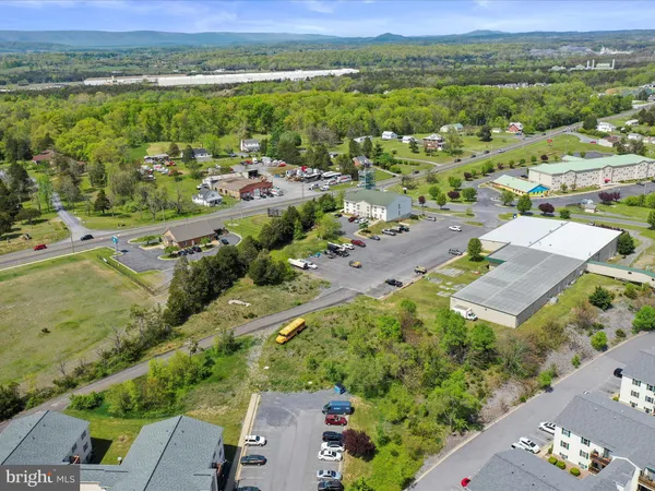 an aerial view of green landscape with trees houses and lake view
