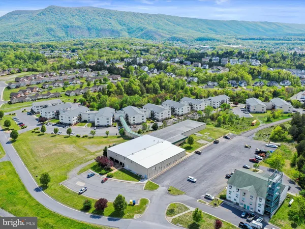 an aerial view of a house with garden space and mountain view in back