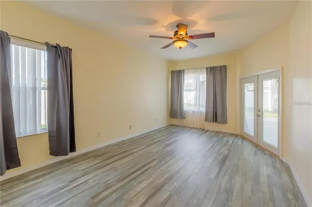 a view of an empty room with wooden floor and a window
