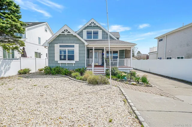 a front view of a house with a yard and potted plants