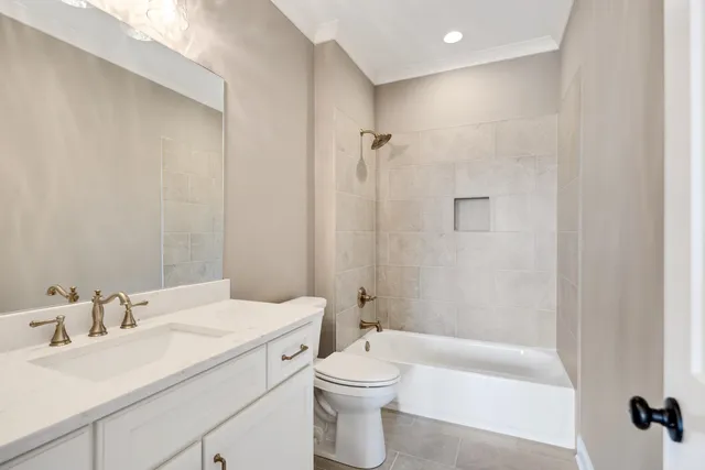 a view of an empty room with wooden floor and a ceiling fan