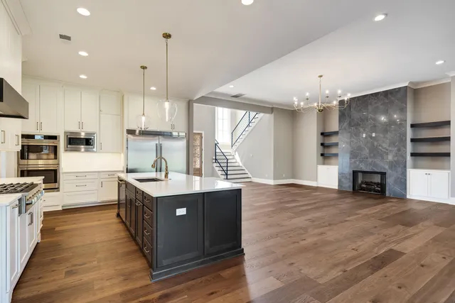 a kitchen with stainless steel appliances granite countertop a sink a stove and a refrigerator