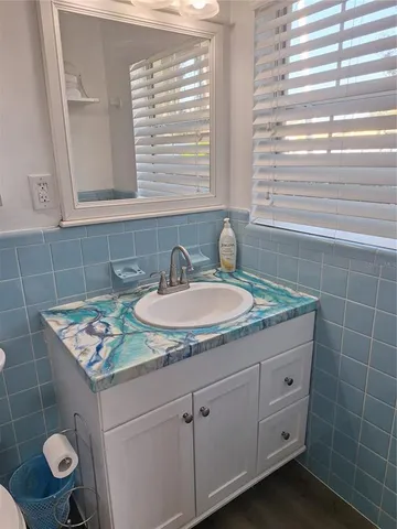 a bathroom with a granite countertop sink a toilet and a mirror