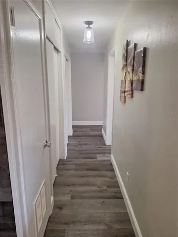 a view of a hallway with wooden floor