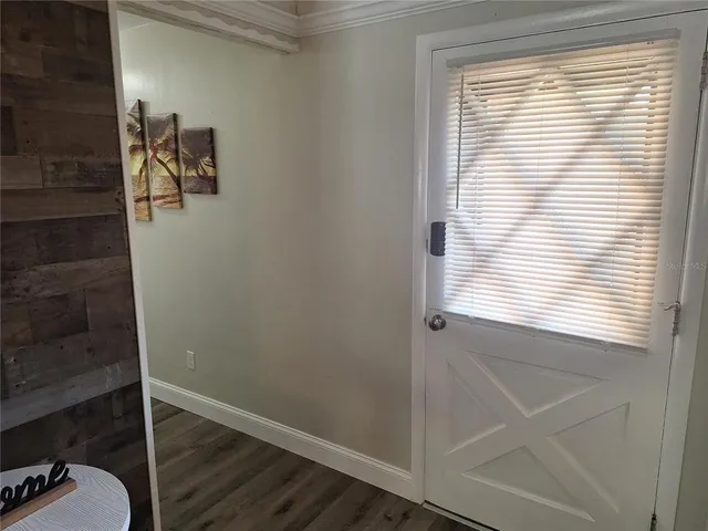 a view of a kitchen with wooden floor and a refrigerator