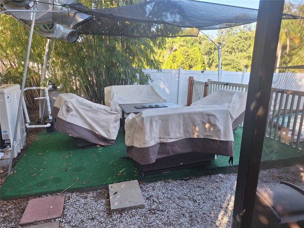1202 South Keene Road Clearwater, FL 33756 - Photo 37 of 46 a view of a patio with a table chairs and a yard