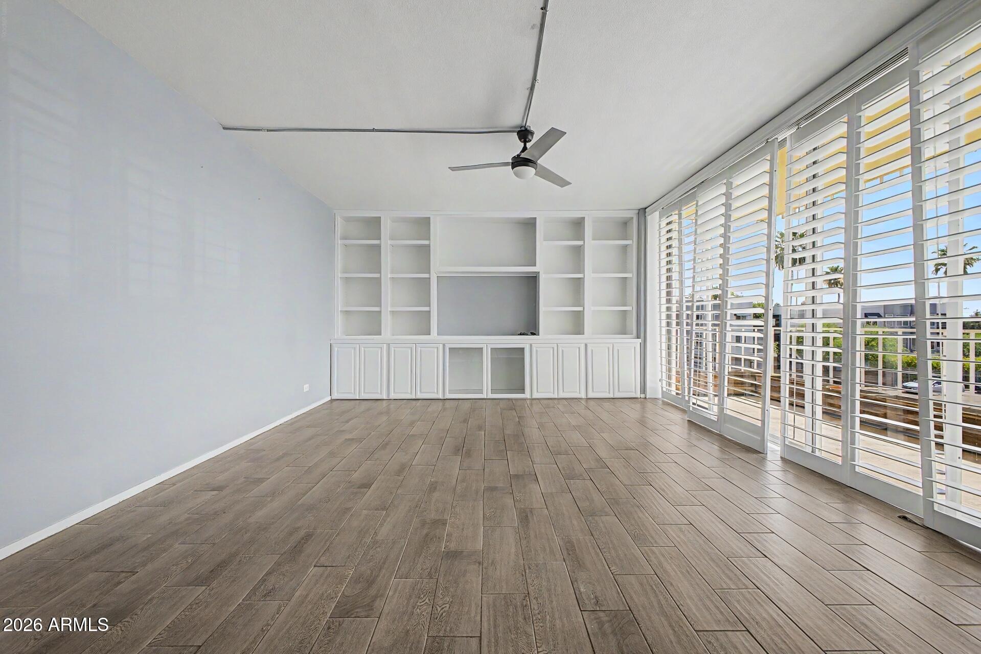 207 West Clarendon Avenue, Unit B2 Phoenix, AZ 85013 - Photo 2 of 30 an empty room with wooden floor and windows