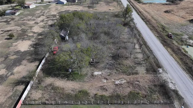 a view of a dry yard with wooden fence